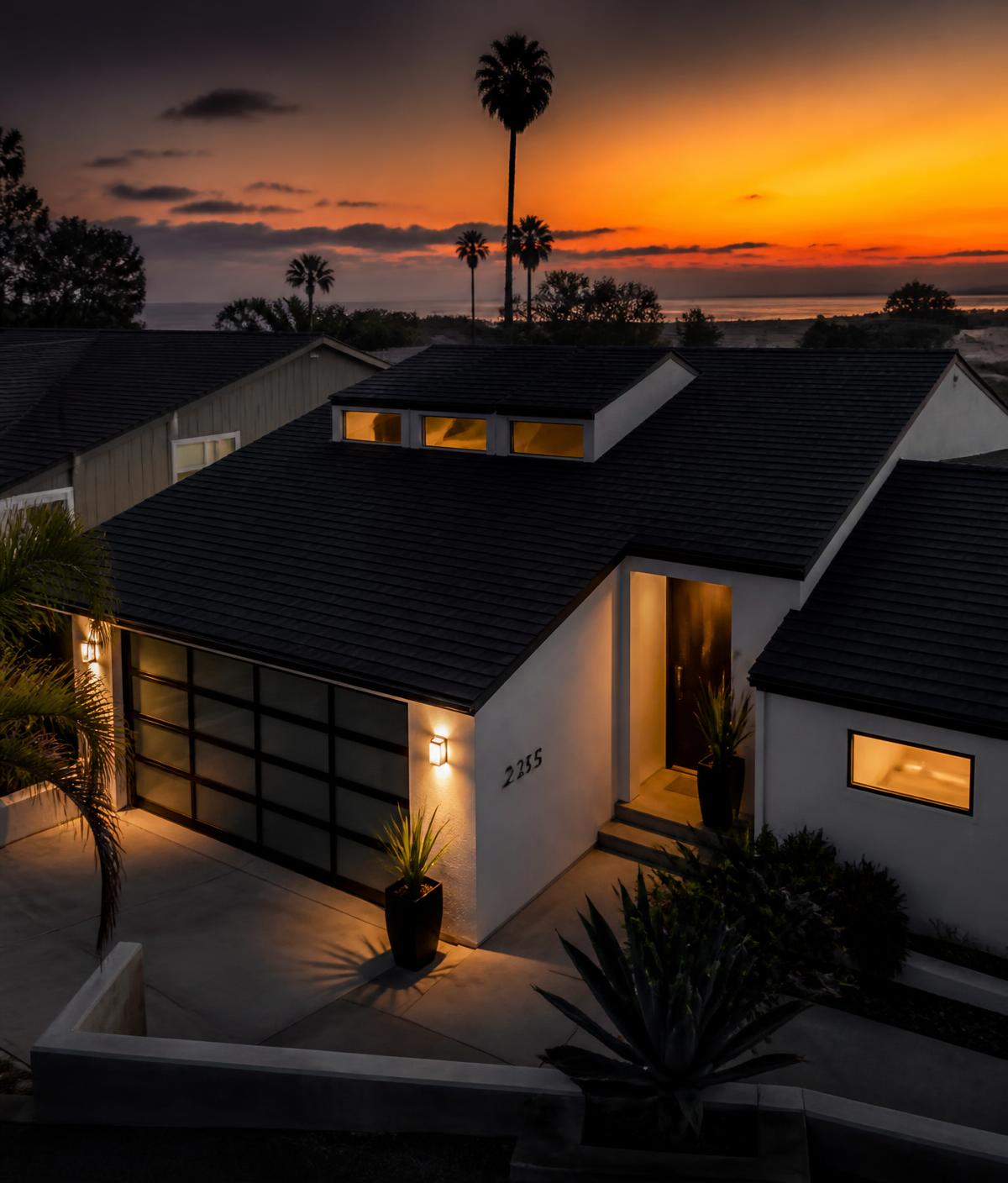 Newly installed dark shingle roof on a home at sunset